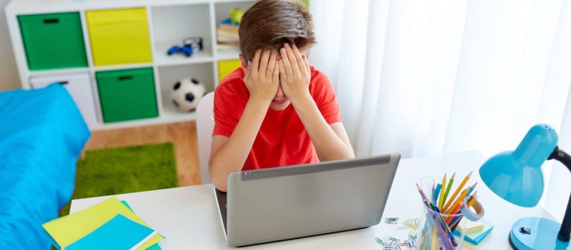 upset student boy with laptop computer at home